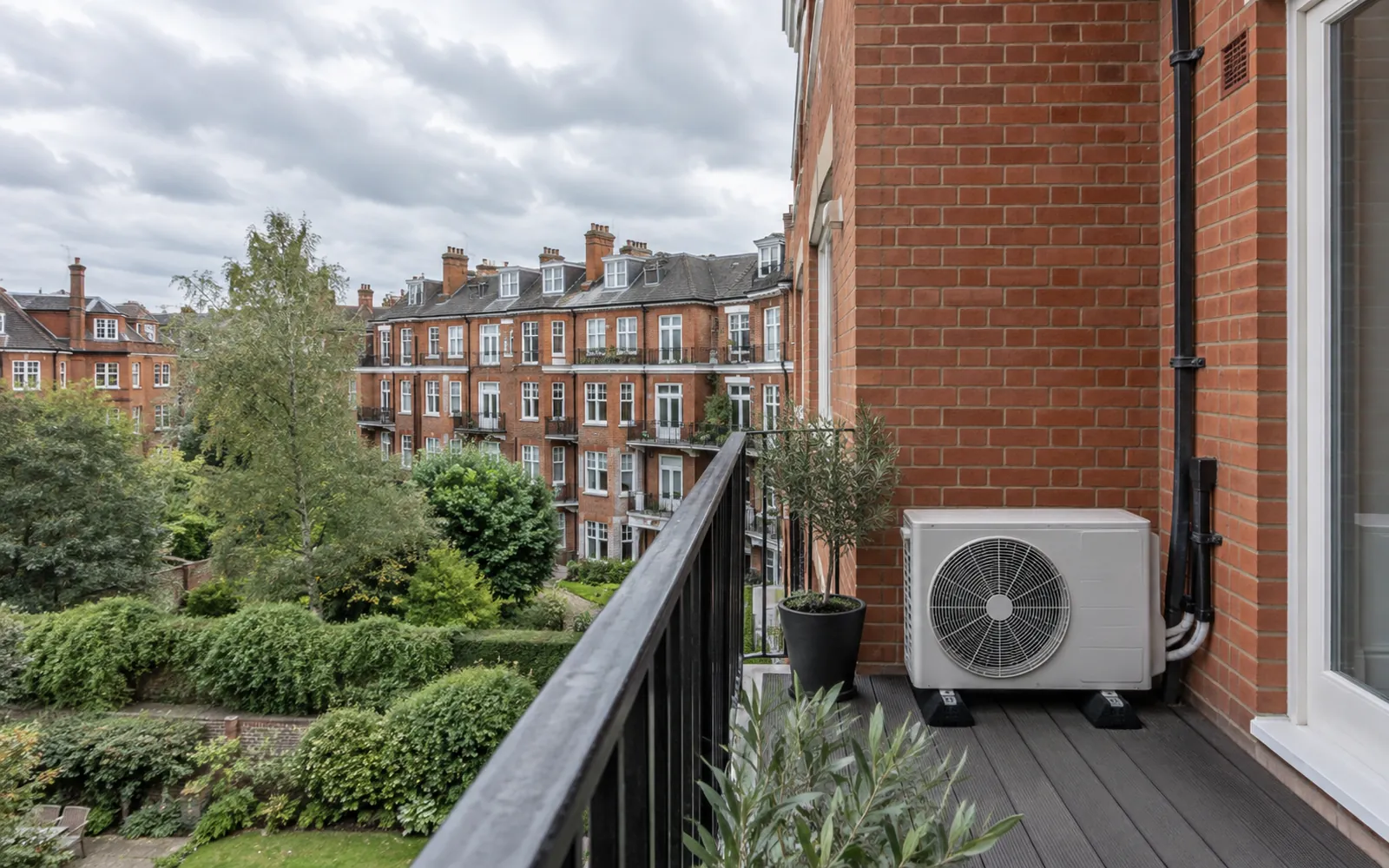 Outdoor air conditioning unit on the balcony of a red-brick London mansion block